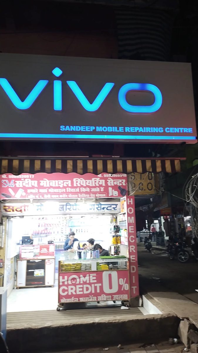 Sandeep Mobile Repairing Centre at night under a lit vivo sign